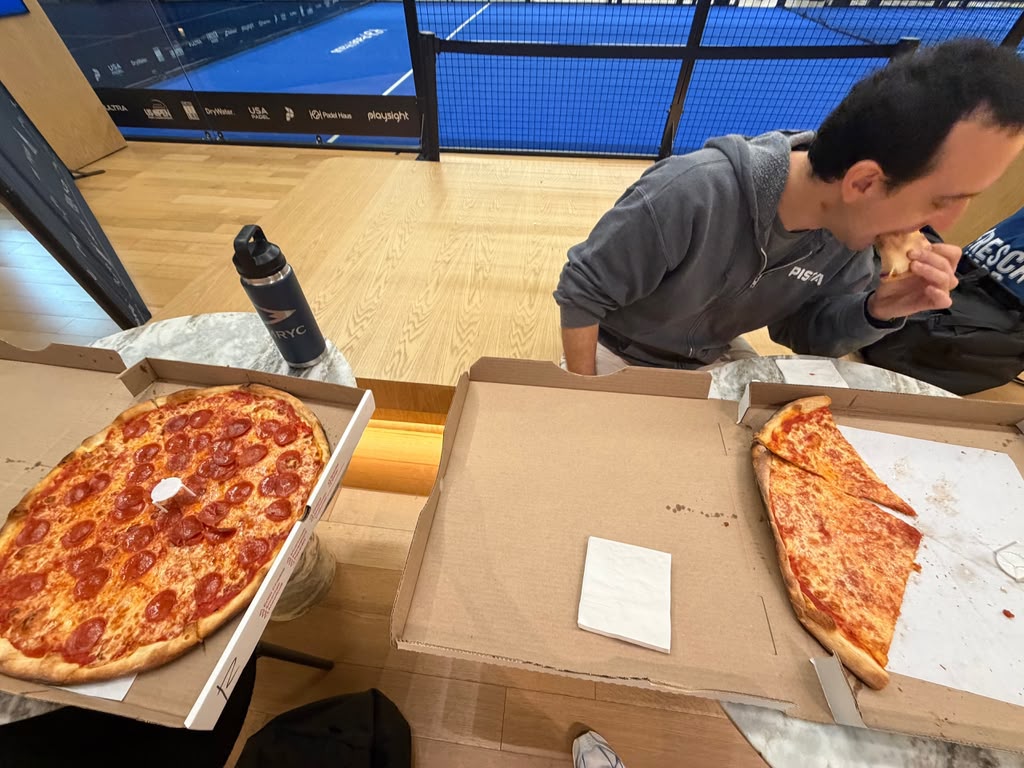 Pizza boxes courtside at the club, one of us mid-bite